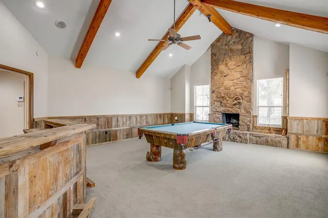 a living room with furniture pool table and a fireplace