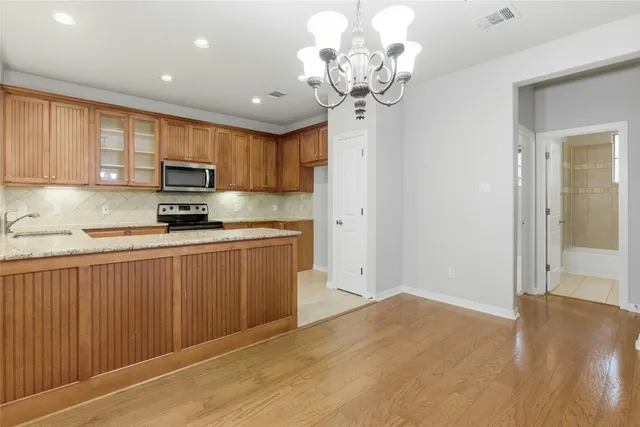 a kitchen with stainless steel appliances granite countertop a refrigerator a sink dishwasher and a stove