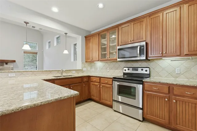 a kitchen with stainless steel appliances granite countertop a sink stove and microwave