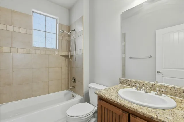 a bathroom with a granite countertop sink toilet mirror and shower