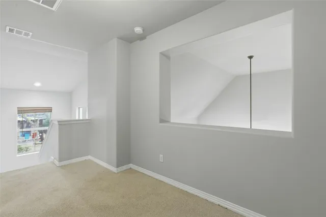 an empty room with windows and cabinet