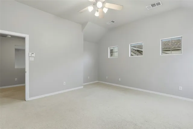 an empty room with a chandelier fan