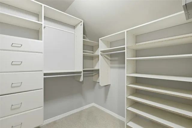 a view of walk in closet with empty racks
