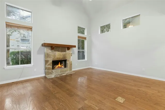 a view of an empty room with a window and fireplace