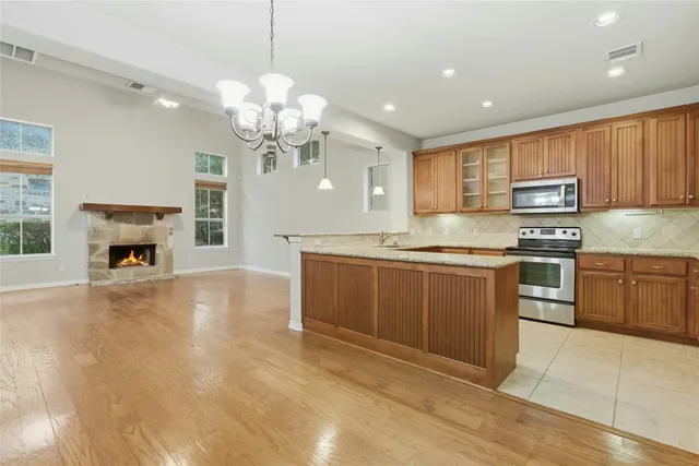 a kitchen with kitchen island granite countertop a stove top oven a sink a counter space and cabinets