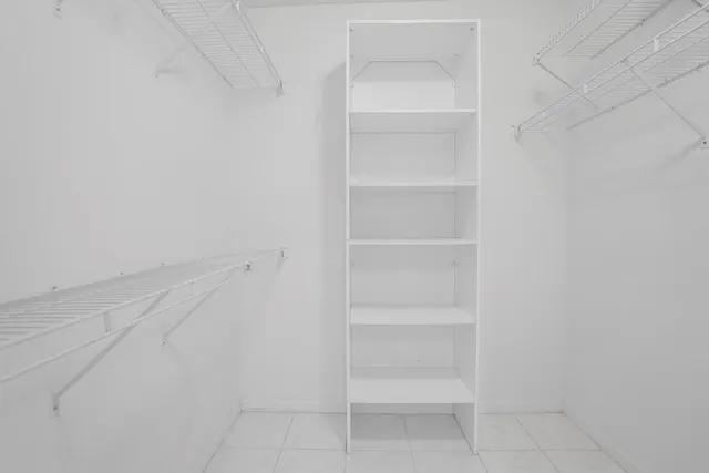 a spacious bedroom with a large bed and a chandelier