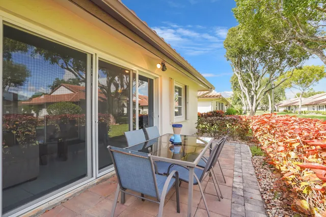 a view of a patio with a table chairs and a backyard