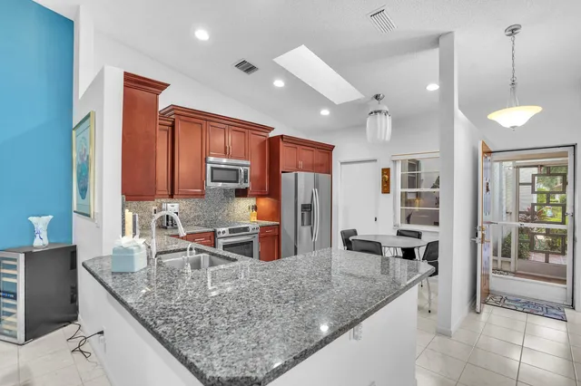 a kitchen with stainless steel appliances granite countertop a sink refrigerator and cabinets