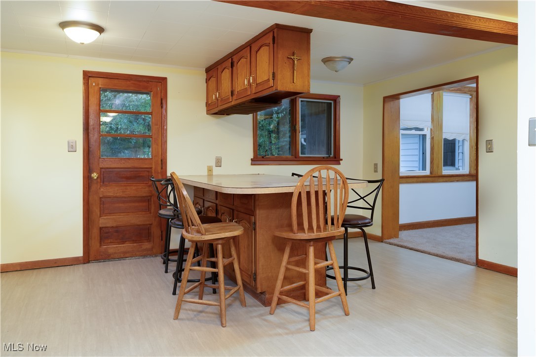 4491 Fox Road Kingsville, OH 44048 - Photo 12 of 33 Kitchen featuring kitchen peninsula, light hardwood / wood-style floors, and a kitchen bar