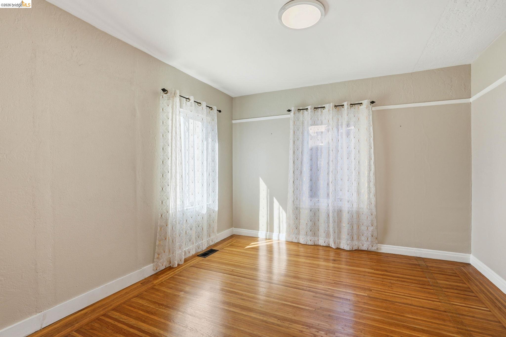 840 Key Rte Boulevard Albany, CA 94706 - Photo 21 of 43 Spare room featuring wood finished floors and baseboards