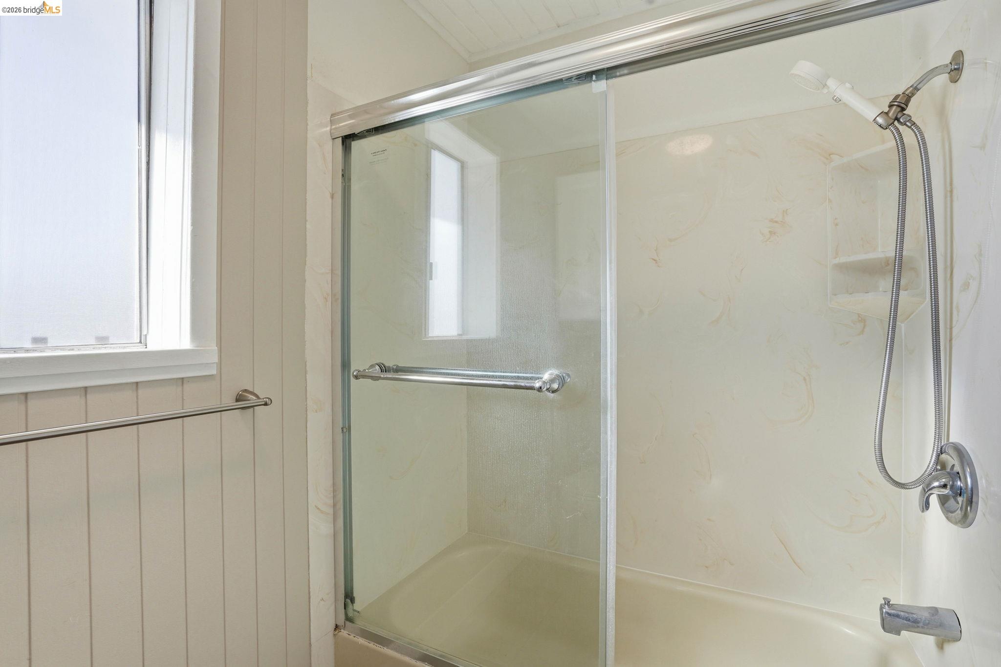 840 Key Rte Boulevard Albany, CA 94706 - Photo 36 of 43 Full bathroom with enclosed tub / shower combo and wooden walls