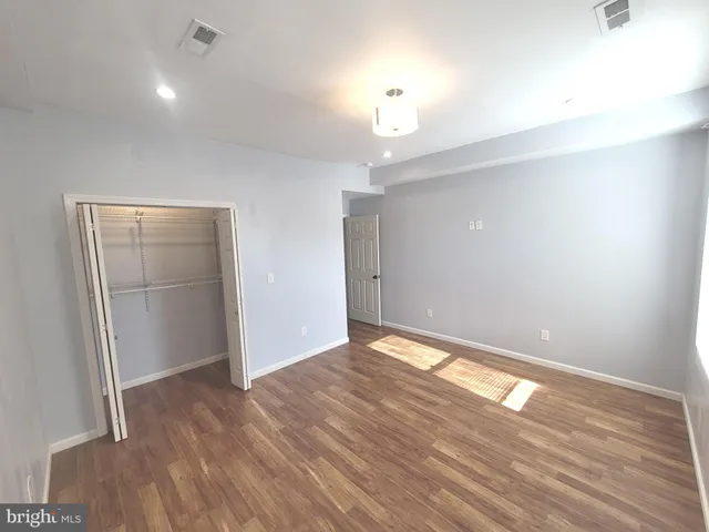 an empty room with wooden floor and entrance