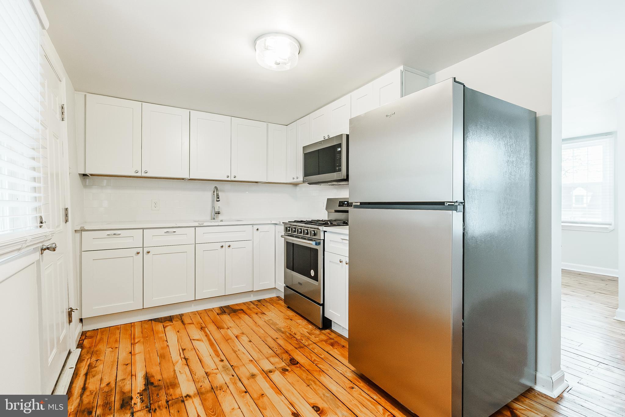 431 Central Avenue Glenside, PA 19038 - Photo 5 of 15 a kitchen with a refrigerator and white cabinets
