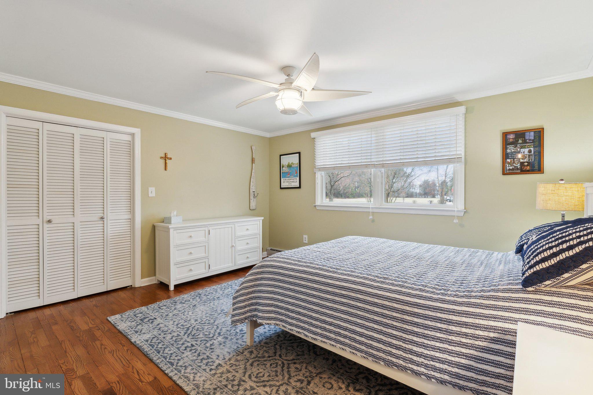 7171 Drum Point Road St. Michaels, MD 21663 - Photo 63 of 70 a bedroom with a bed and a table with wooden floor