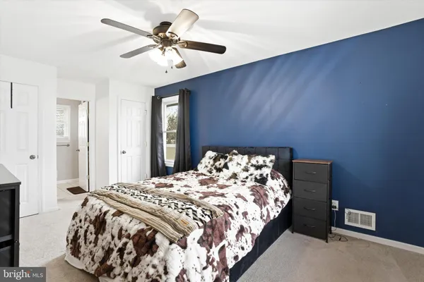 a bedroom with a bed and a ceiling fan