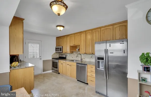 a kitchen with stainless steel appliances granite countertop a sink a stove and a refrigerator