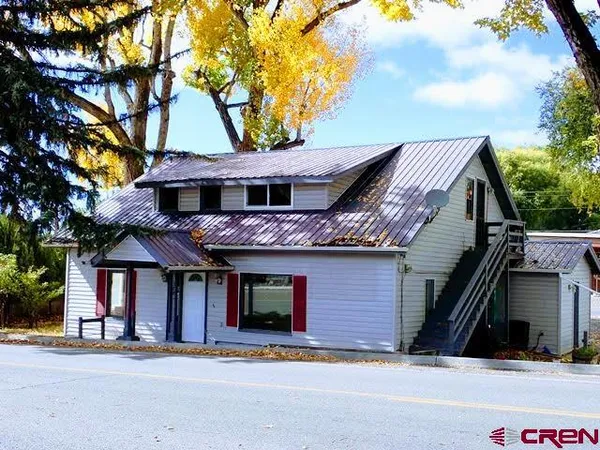 a front view of a house with a tree