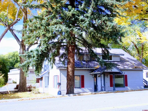 a front view of a house with a yard and trees