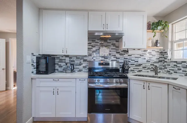 a kitchen with white cabinets and appliances
