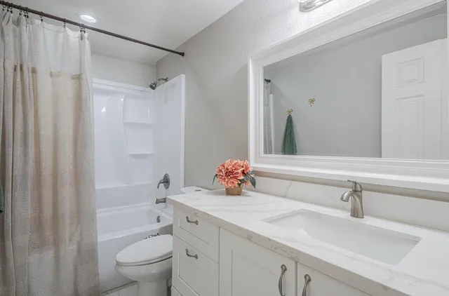a bathroom with a sink vanity mirror and toilet