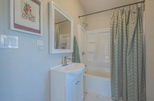 a bathroom with a shower a sink and a mirror