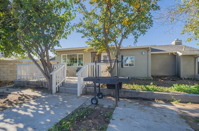 a view of a house with backyard and sitting area