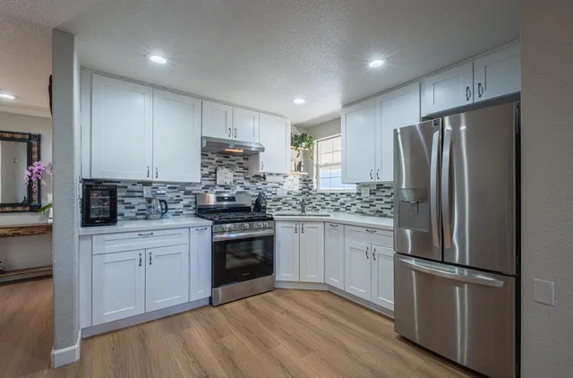 a kitchen with a refrigerator stove and white cabinets