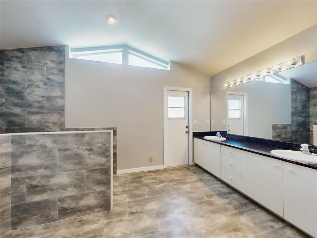 116 Wood Ridge Trail Sanford, FL 32771 - Photo 31 of 49 a large bathroom with a granite countertop sink and a mirror