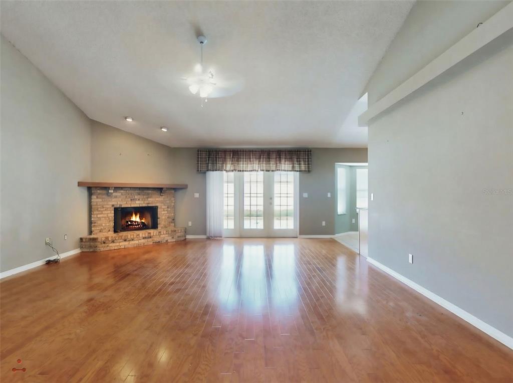 116 Wood Ridge Trail Sanford, FL 32771 - Photo 5 of 49 an empty room with wooden floor fireplace and windows