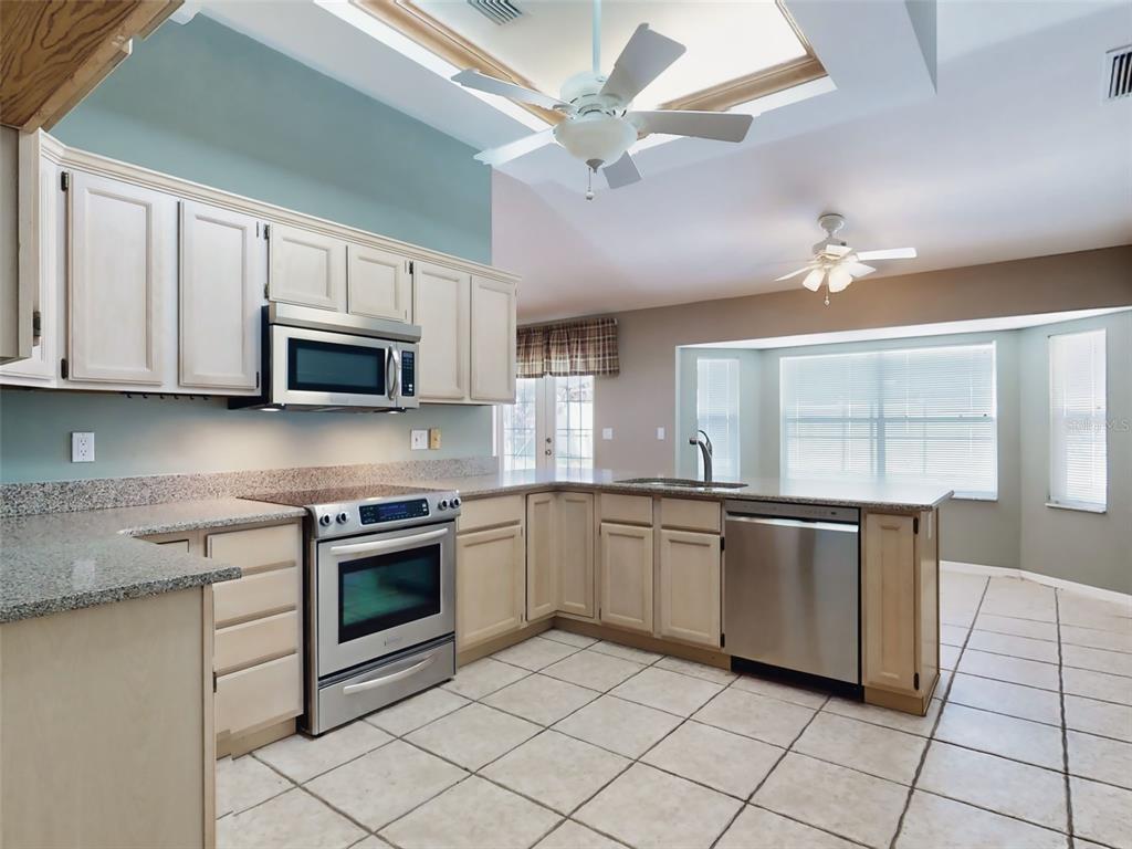 116 Wood Ridge Trail Sanford, FL 32771 - Photo 10 of 49 a kitchen with stainless steel appliances granite countertop a stove cabinets and microwave