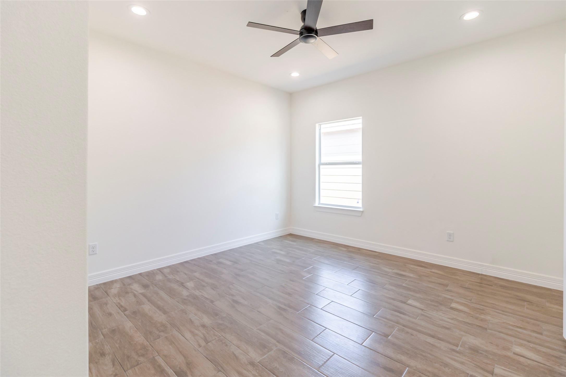 309 Myrtle Road Smithville, TX 78957 - Photo 13 of 17 The first secondary bedroom gets the same wood-look tile, plus a ceiling fan and long walls that keep furniture placement flexible.