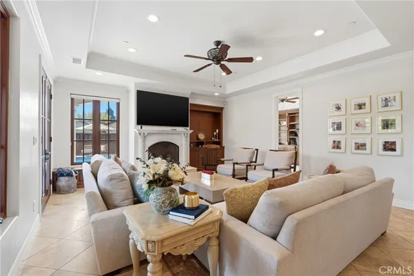 a living room with furniture a fireplace and a chandelier