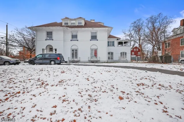 a large white building with a view of snow in front of it