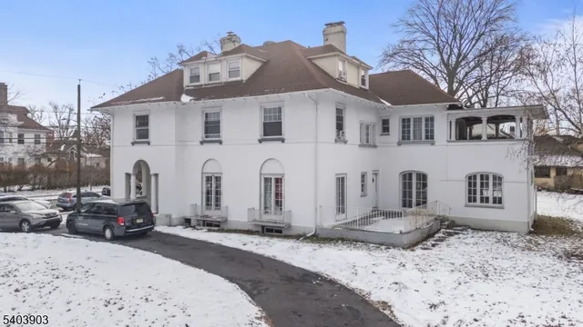 a front view of a house with a yard covered with snow