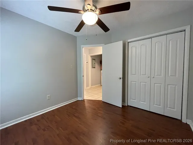 an empty room with wooden floor a ceiling fan and closet
