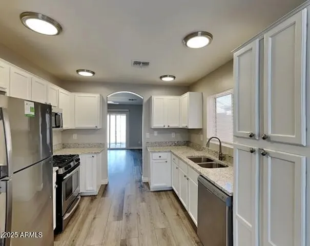 a kitchen with a sink a refrigerator and cabinets