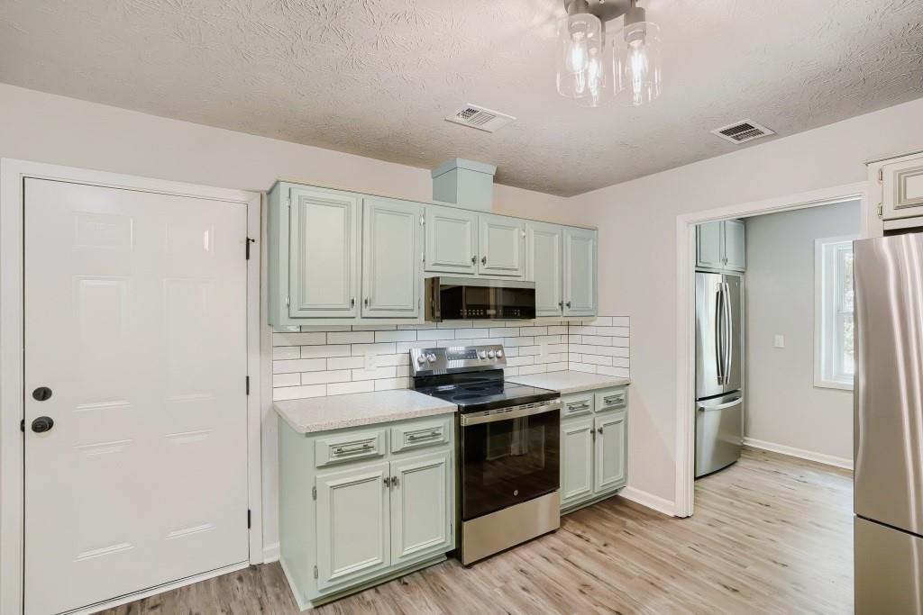 2021 Irwin Bridge Road Northwest Conyers, GA 30012 - Photo 15 of 43 a kitchen with stainless steel appliances a refrigerator stove and sink