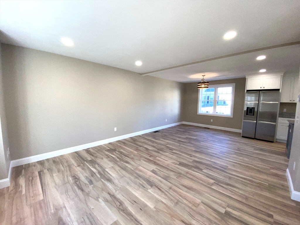 152 West Main Street, Unit A Millbury, MA 01527 - Photo 11 of 33 an empty room with wooden floor and windows