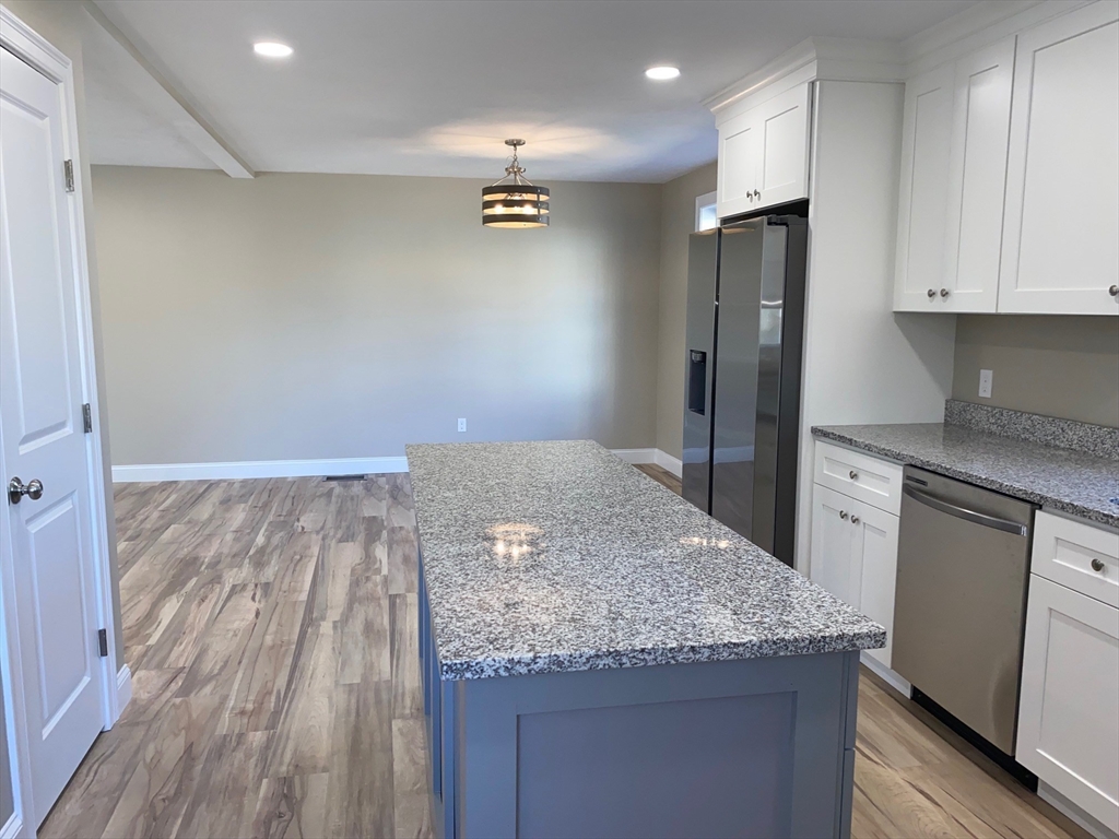 152 West Main Street, Unit A Millbury, MA 01527 - Photo 16 of 33 a kitchen with granite countertop a refrigerator and a stove top oven