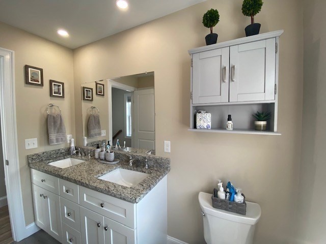152 West Main Street, Unit A Millbury, MA 01527 - Photo 17 of 33 a bathroom with a granite countertop sink a mirror and a toilet