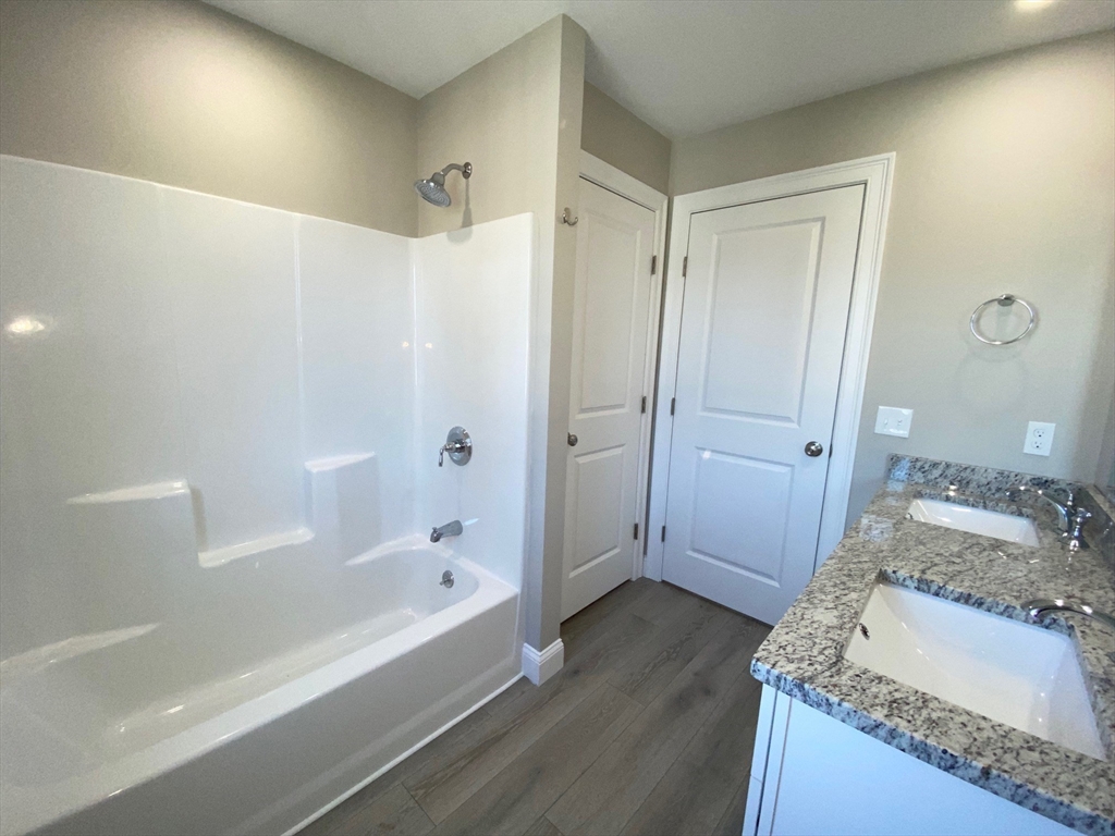152 West Main Street, Unit A Millbury, MA 01527 - Photo 19 of 33 a spacious bathroom with a granite countertop tub sink and mirror