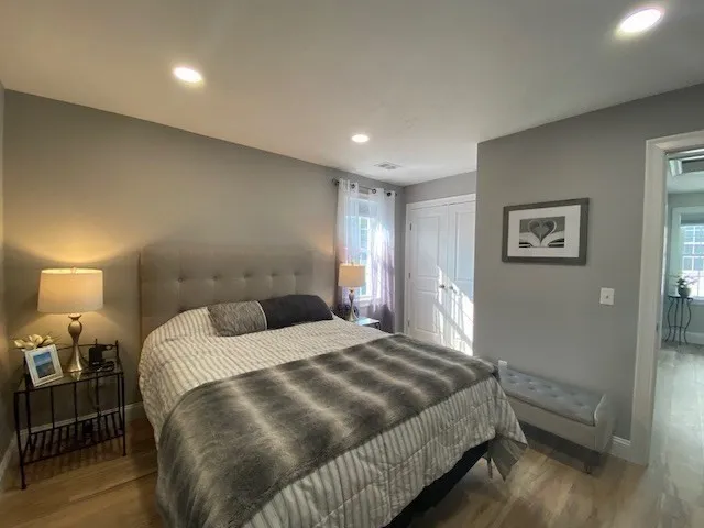 a bedroom with a bed and wooden floor