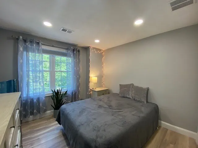 a bedroom with a bed and wooden floor