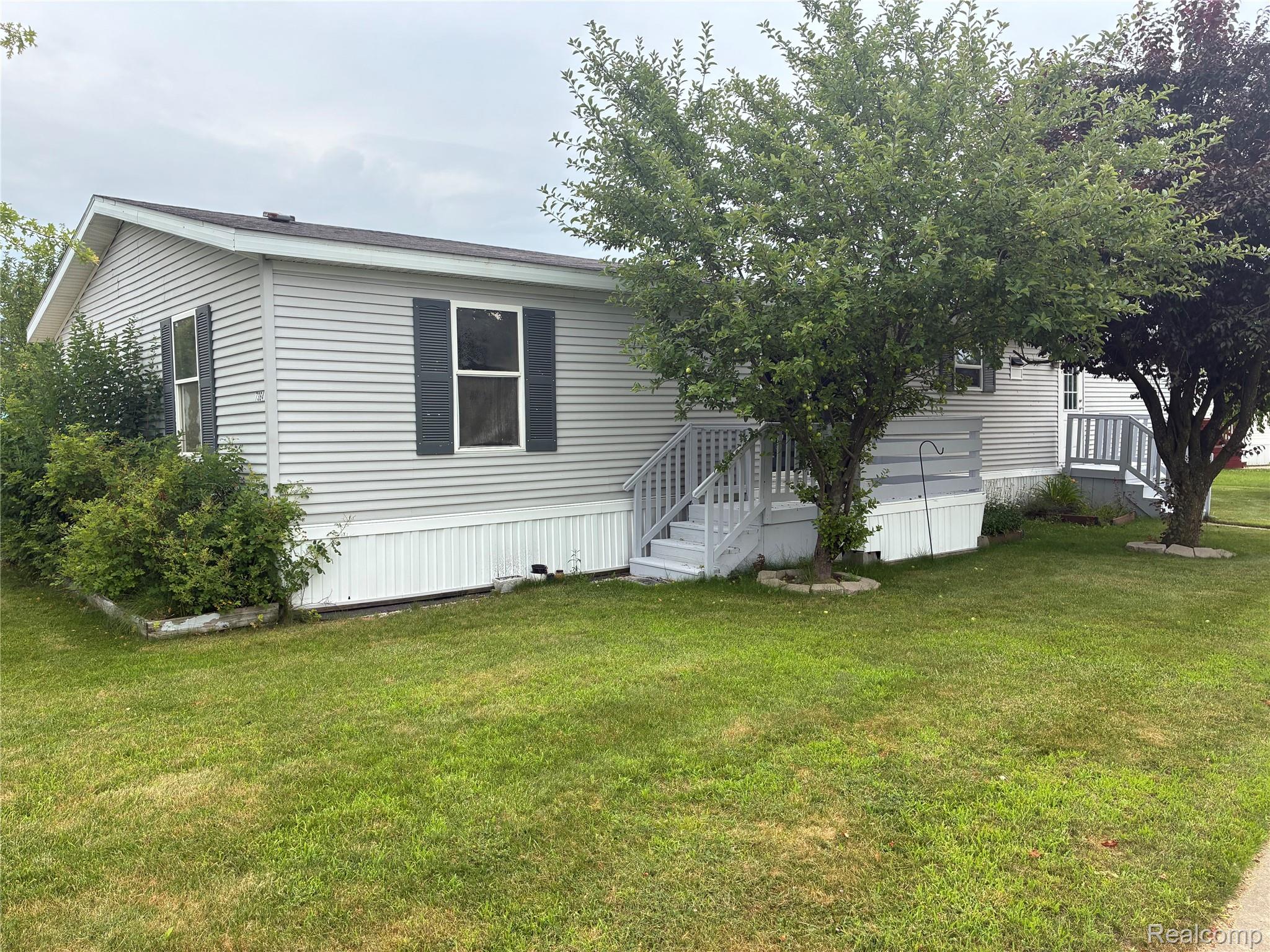 7364 Kings Court Alma, MI 48801 - Photo 3 of 16 Light gray siding exterior with dark gray shutters