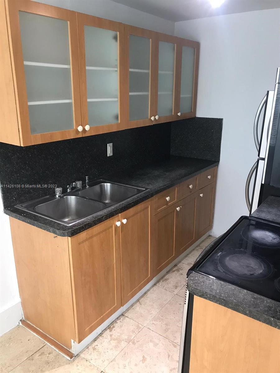 Flamingo-Lummus Miami Beach, FL 33139 - Photo 2 of 13 a kitchen with granite countertop a sink and a black white stove next to a large window