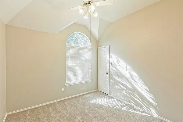 an empty room with windows and ceiling fan