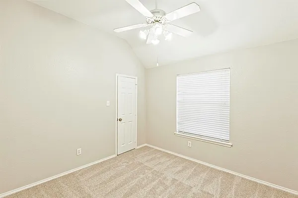an empty room with windows and fan