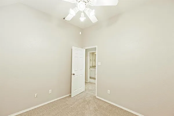 an empty room with a ceiling fan and a window