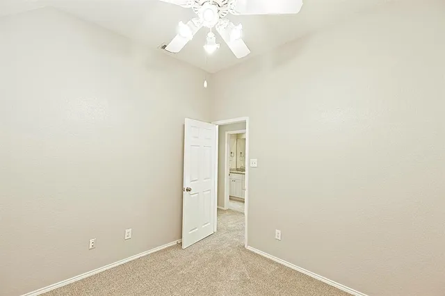 an empty room with a ceiling fan and a window