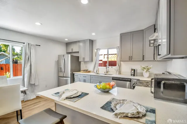 a kitchen with a refrigerator and a stove top oven